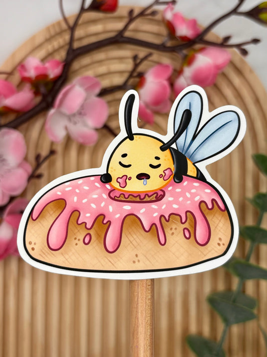 Close-up van sticker met schattige bij slapend op donut.