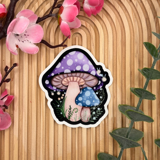 Die-cut sticker van blauwe en paarse paddenstoelen met fireflies.