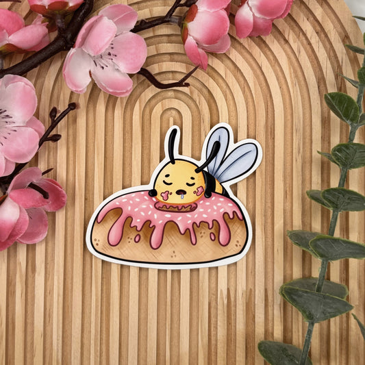 Die-cut sticker van slapende bij op donut.